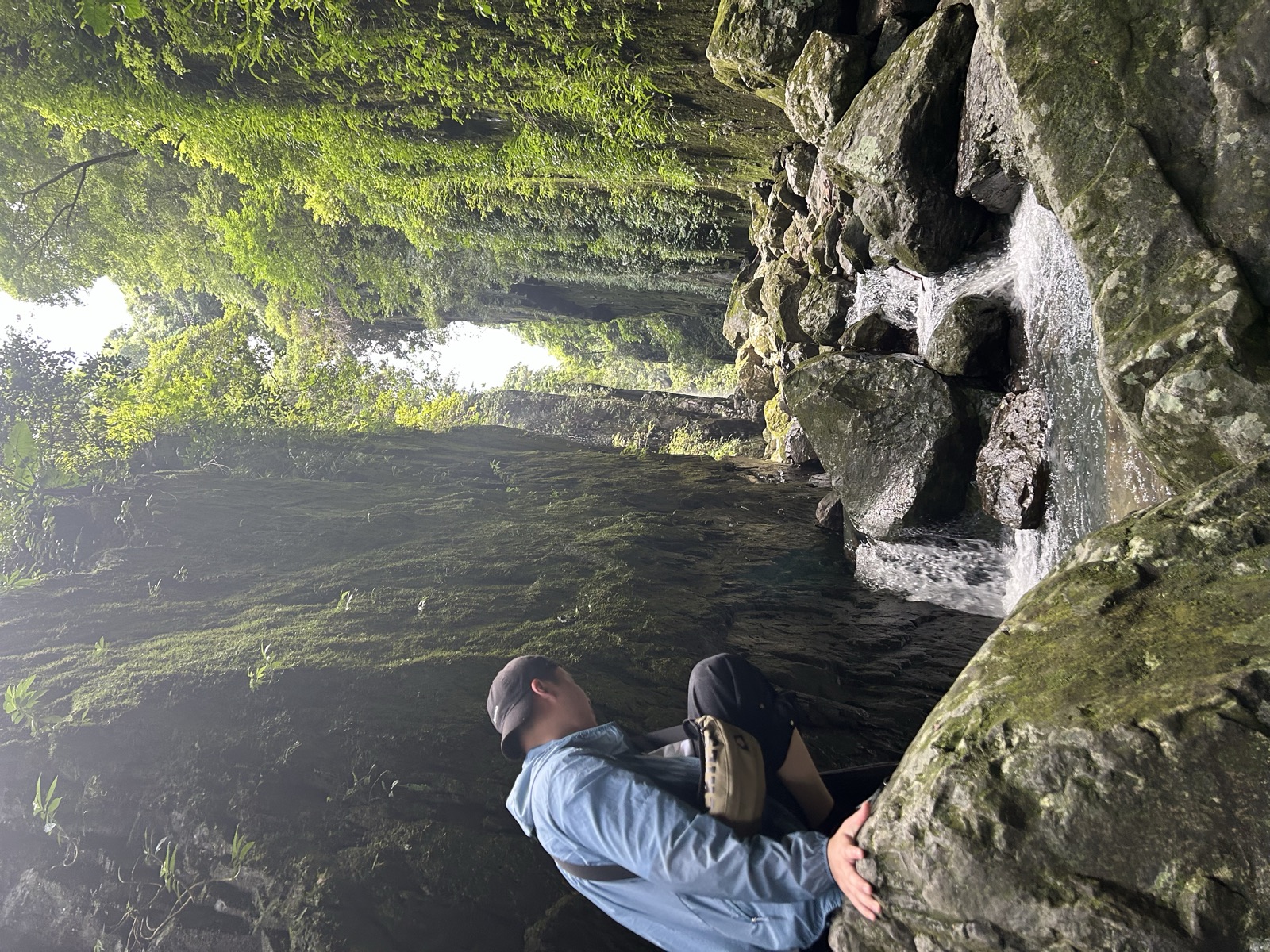 Linkai Li climbing beside a rocky stream during an adventure
